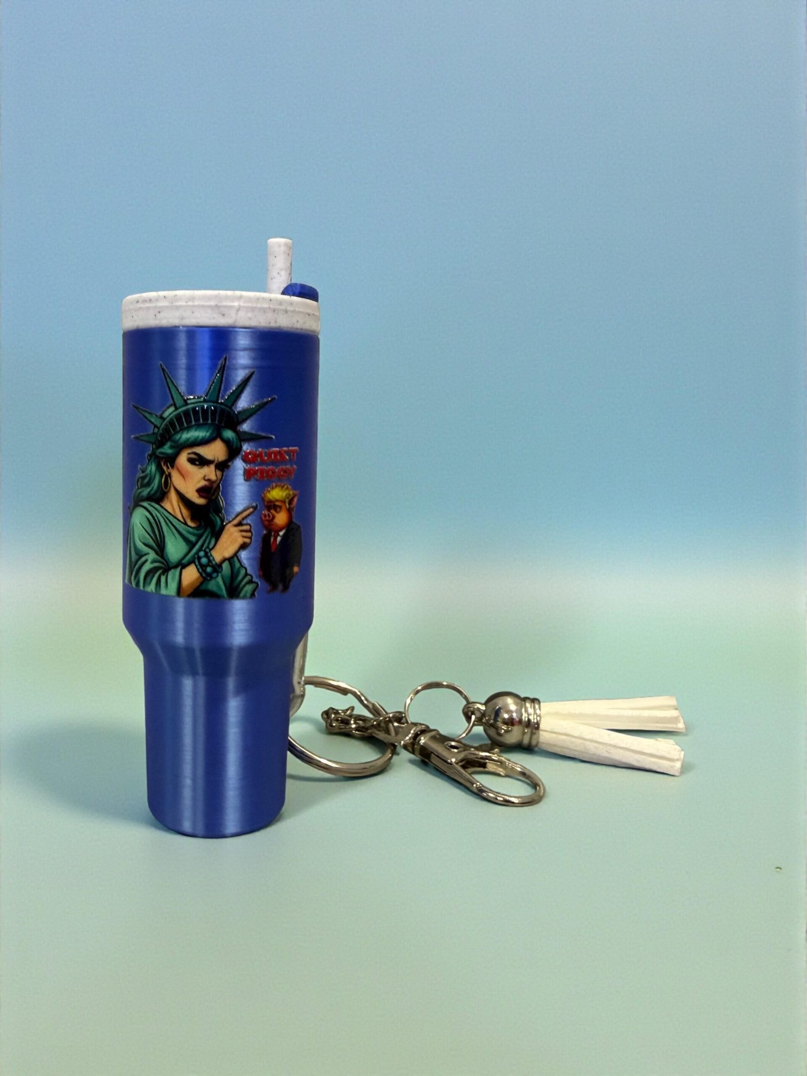 5fc1808919e34eccac919ea2853b4347~tplv-fhlh96nyum-origin-jpeg Mini tumbler-shaped keychain featuring a satirical graphic attached to a metal keyring