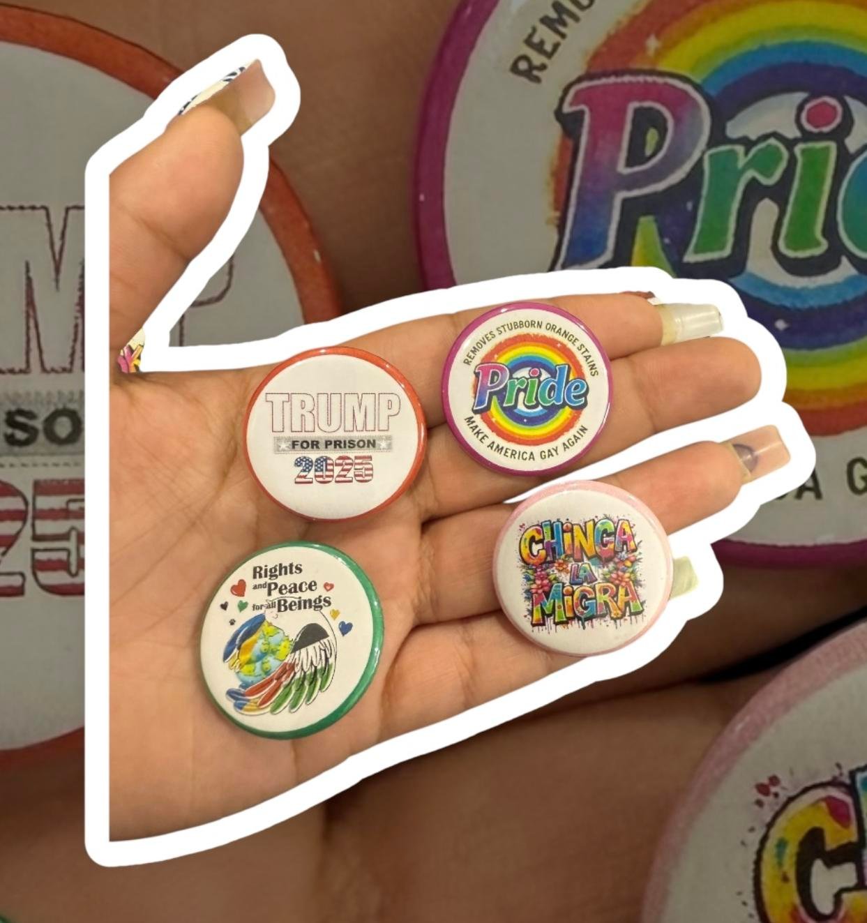 6e5c696ddc9c4c3e99dd839f86c1cf95~tplv-fhlh96nyum-origin-jpeg A hand holding several round button pins with expressive designs and bold text.