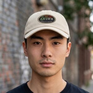 dad hat featuring an oval patch reading “We Are All Antifa – Know Your History.”