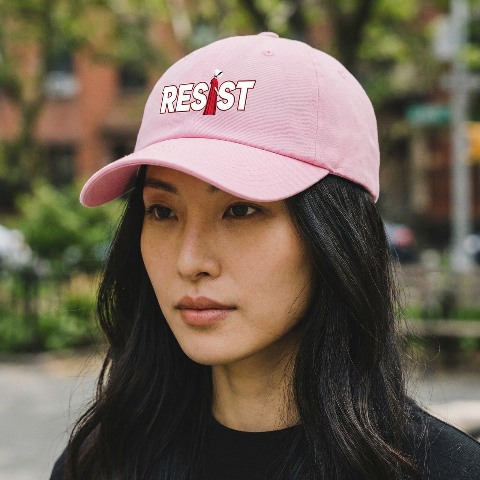 ResistHandMaidHat dad hat with the word “RESIST” and a red-cloaked resistance figure.