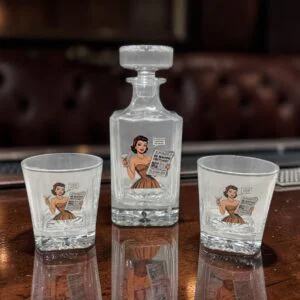 glass whiskey decanter set with retro woman illustration reading big beautiful obituary headline