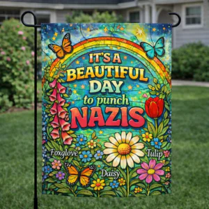 Sublimated rainbow floral garden flag with anti-fascist statement text displayed outdoors.